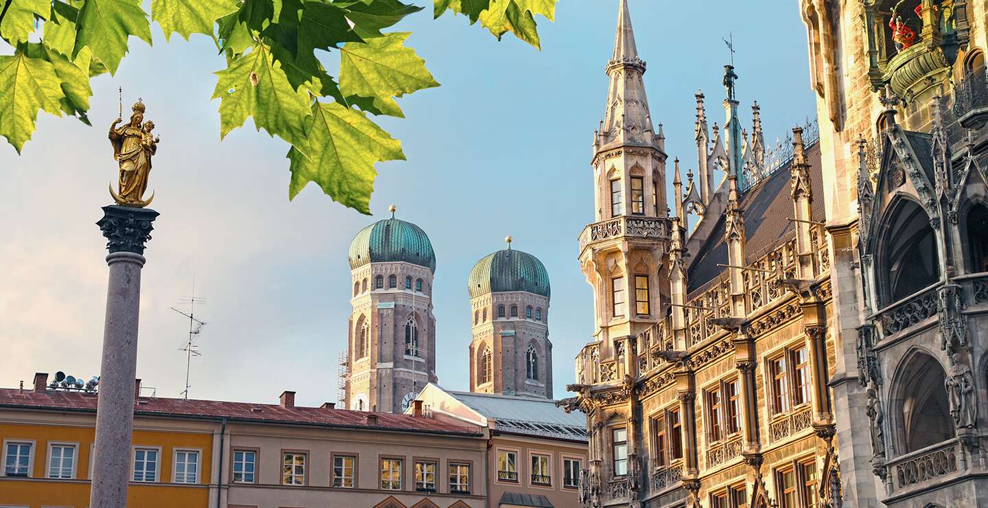 Muenchen Marienplatz | © Gettyimages.com/alexsl Untersicht auf den marienplatz mit Frauenkirche, Rathaus und Blaettern am oberen Rand des Bildes | © Gettyimages.com/alexsl