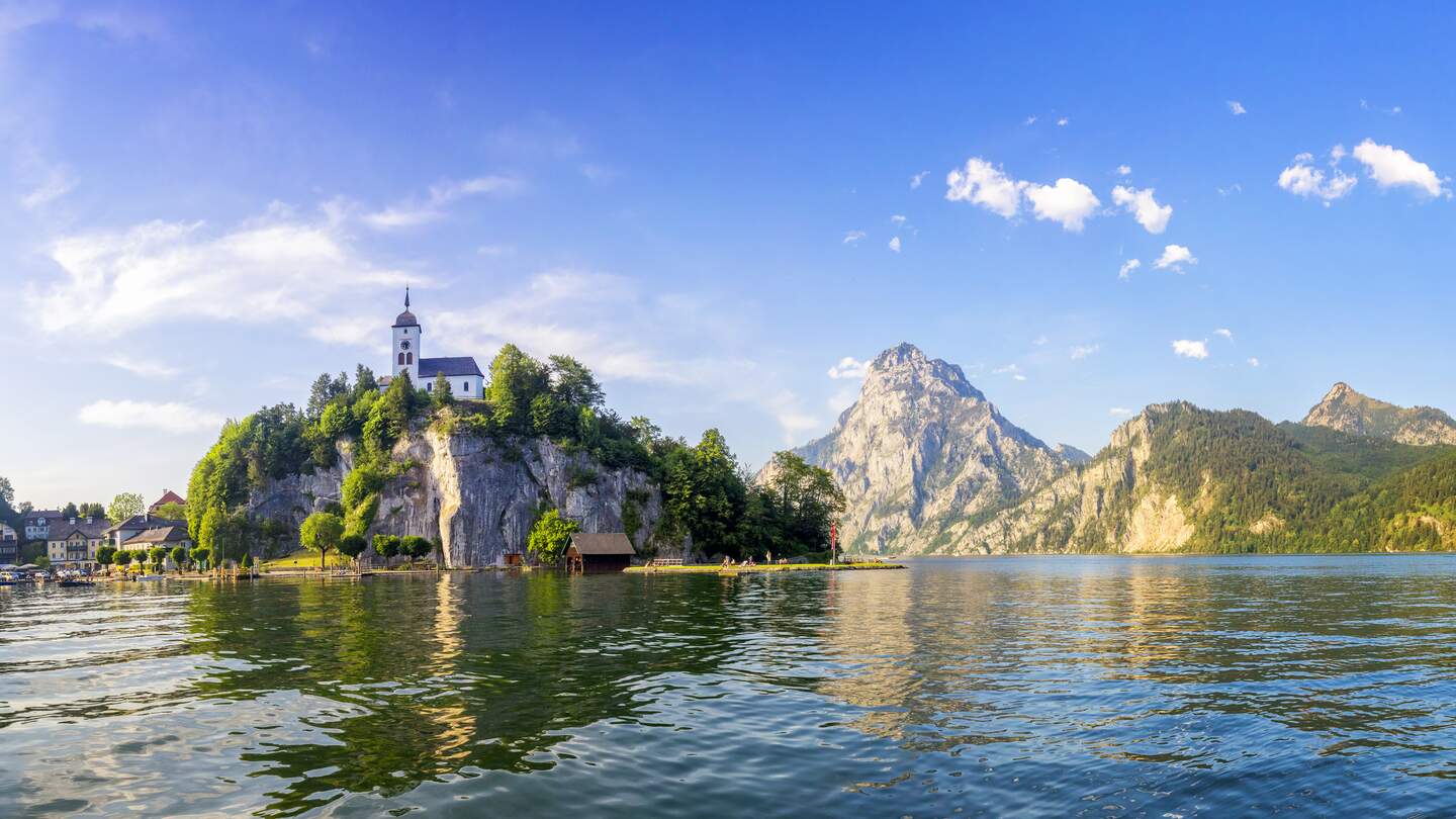 Im Vordergrund ist der See, doch im Zentrum steht die Kapelle auf dem Berg | © Gettyimages.com/dietermeyrl