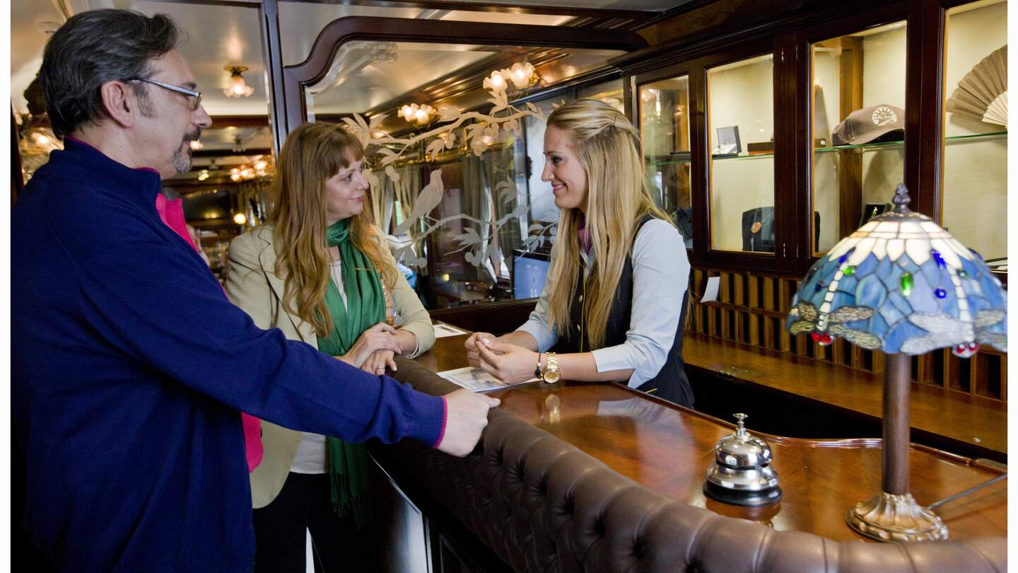 Ein Paar im El Tren al Andalus  | © Renfe Ein Paar lässt sich an Board des El Tren al Andalus von einer Mitarbeiterin beraten. | © Renfe