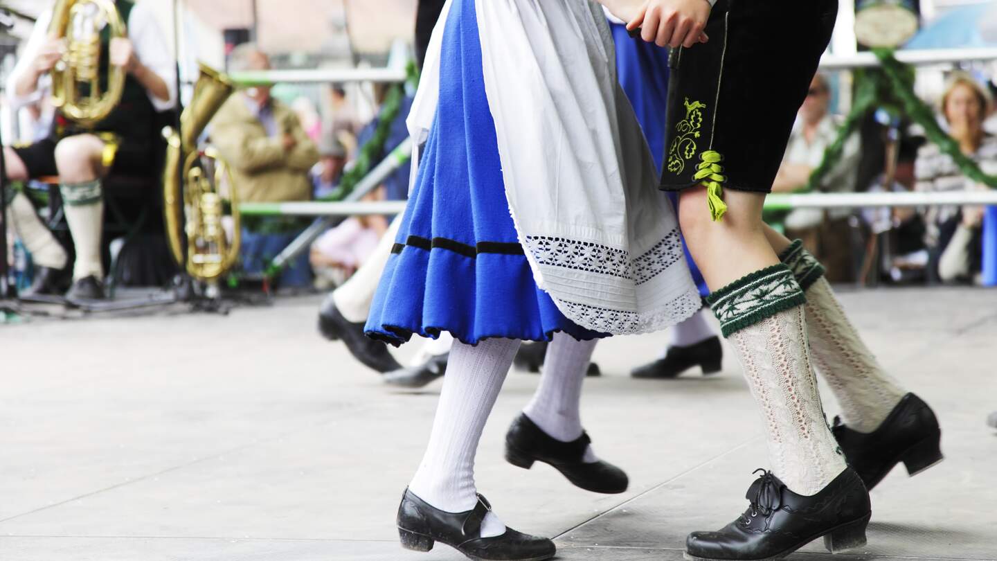 Paar tanzt in traditioneller bayrischer Tracht auf dem Oktoberfest | © Gettyimages.com/sebastian-julian