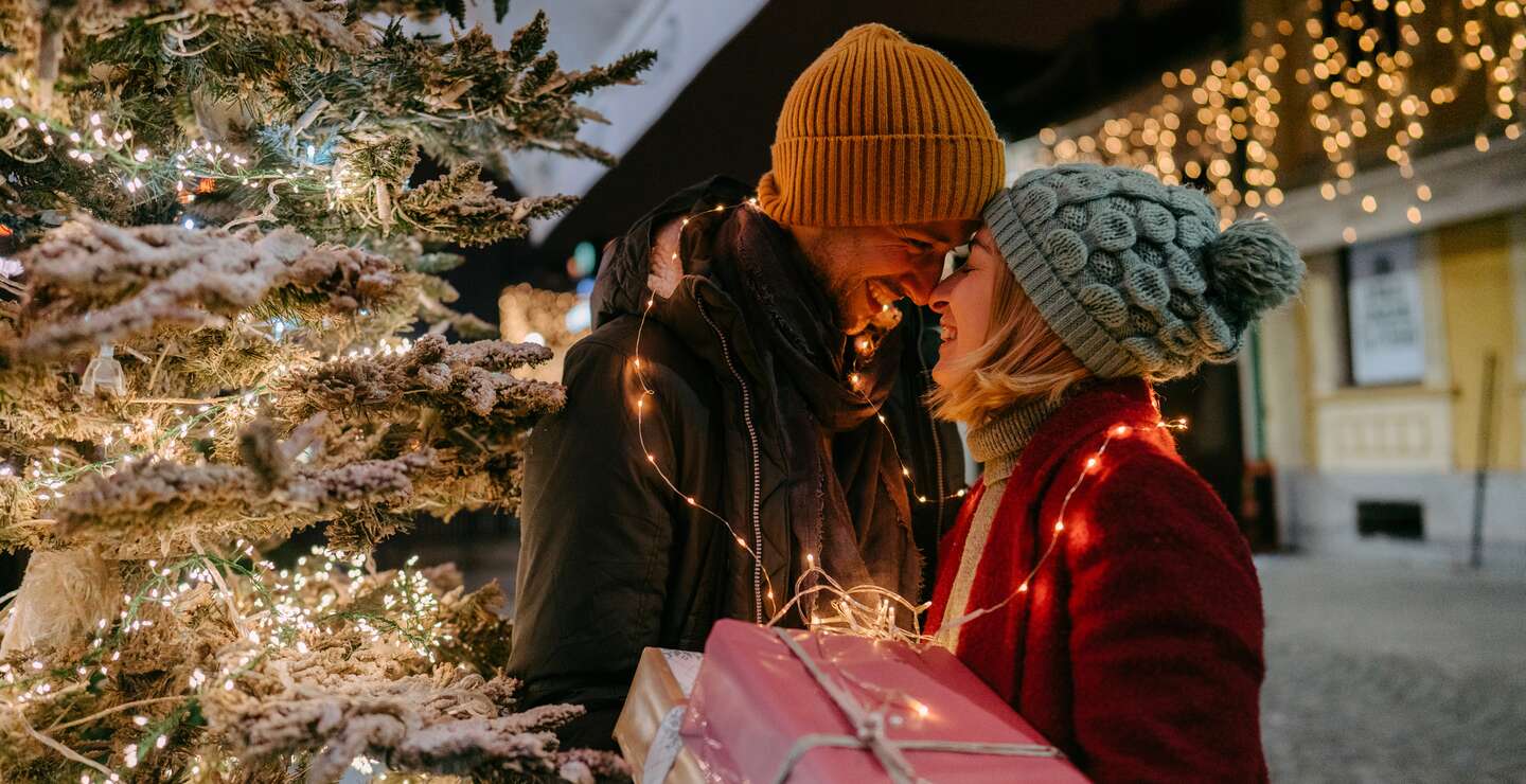 Romantisches Paar mit Weihnachtsgeschenken | © Gettyimages.com/AleksandarNakic Foto eines romantischen Paares mit Weihnachtsgeschenken im Freien | © Gettyimages.com/AleksandarNakic