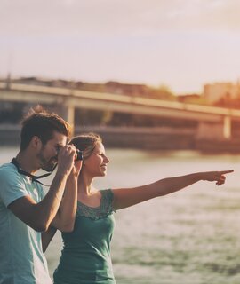 Paar in einer Stadt im Sommer  | © Gettyimages.com/Ines Bazdar Paar in einer Stadt im Sommer. Mann macht Foto mit einer Kamera. | © Gettyimages.com/Ines Bazdar