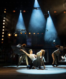 KU’DAMM 59 - Berlins Hit-Musical geht weiter! | © Dominic Ernst Szenenbild mit Celina dos Santos als Monika, Mathias Reiser als Freddy und Ensemble von KU’DAMM 59 - Berlins Hit-Musical geht weiter! | © Dominic Ernst