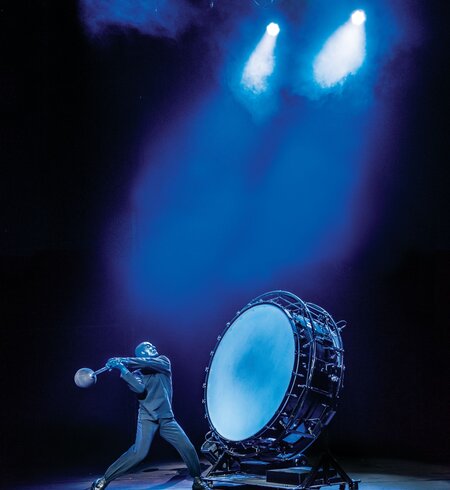Einer der Künstler schlägt auf eine riesige Trommel | © Stage Entertainment