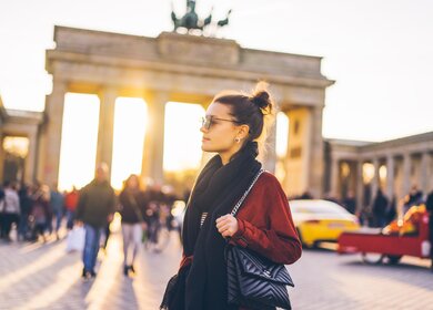 Portrait einer jungen Frau vor dem Brandenburger Tor in Berlin | © Gettyimages.com/Xsandra