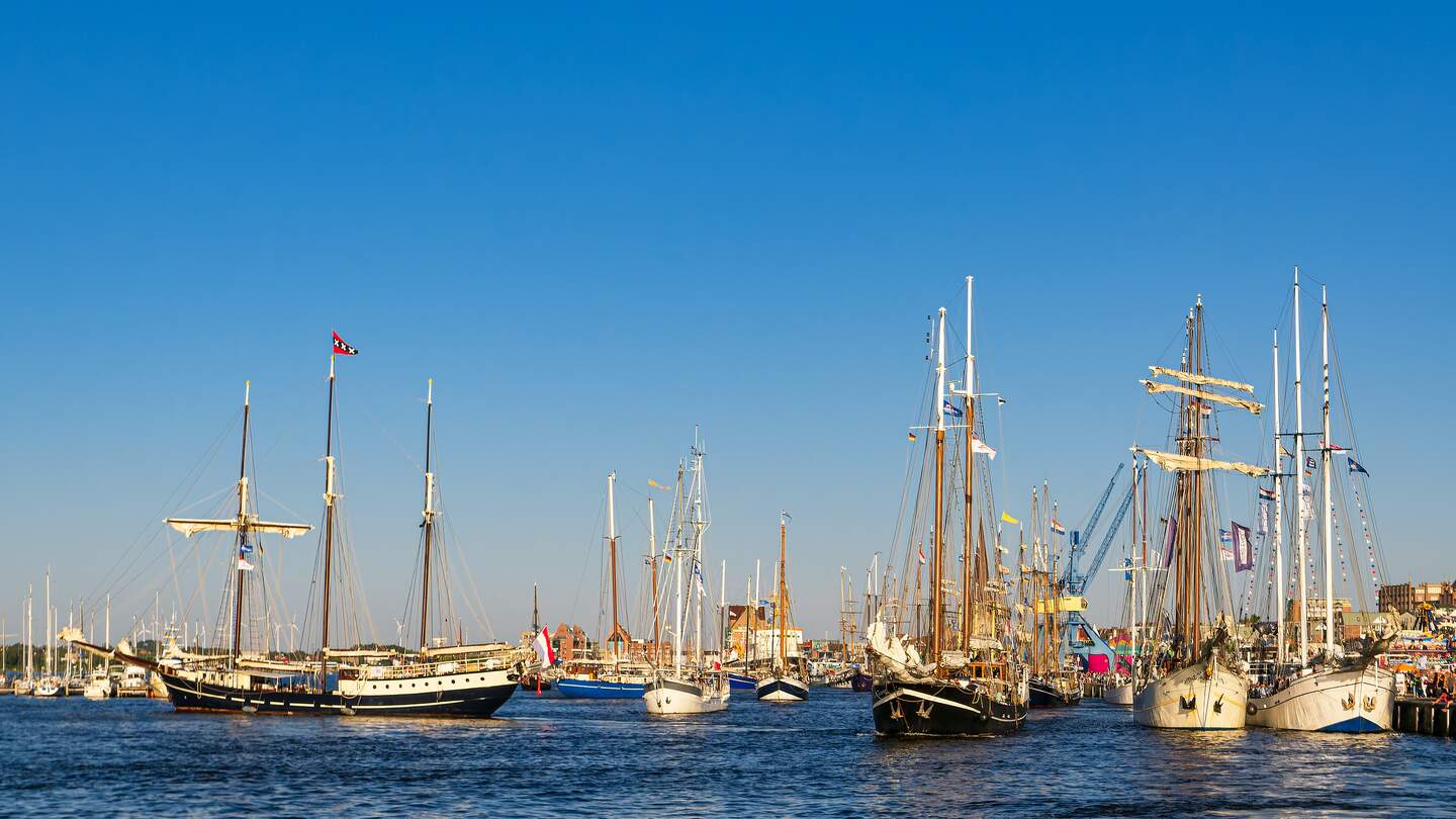 Windjammer auf der Hanse Sail in Rostock mit vielen Segelbooten bei blauem Himmel | © Gettyimages.com/RicoK69