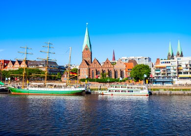 Blick auf Weser Flussufer in Bremen mit Booten und Altstadt im Hintergrund | © Gettyimages.com/saiko3p
