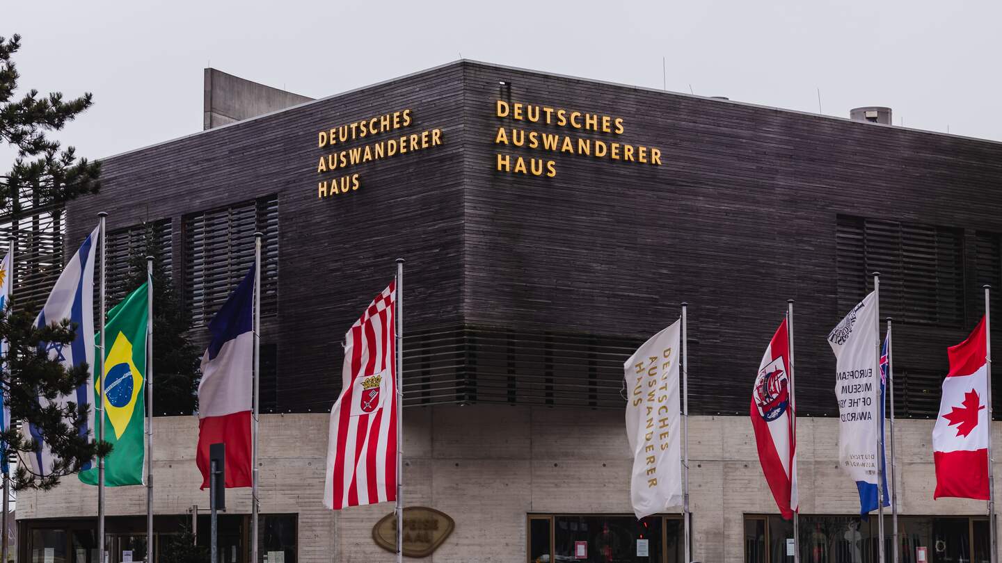 Deutsche Auswandererhaus in Bremerhaven mit Fahnen vor der dem Museum | © Gettyimages.com/Wirestock