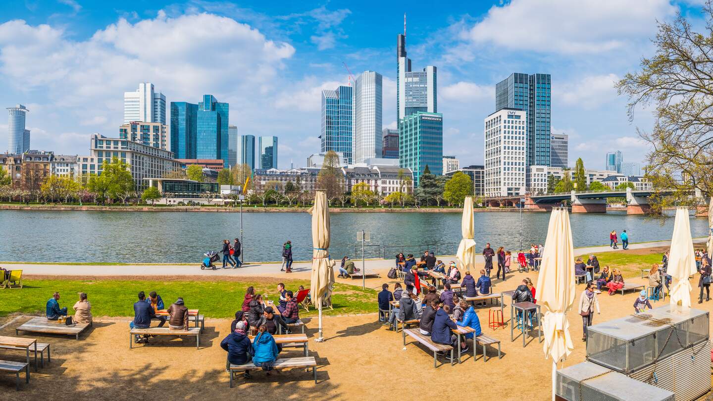 Viele Menschen sitzen in einem Cafe im Freien am Mainufer von Frankfurt | © Gettyimages.com/fotoVoyager