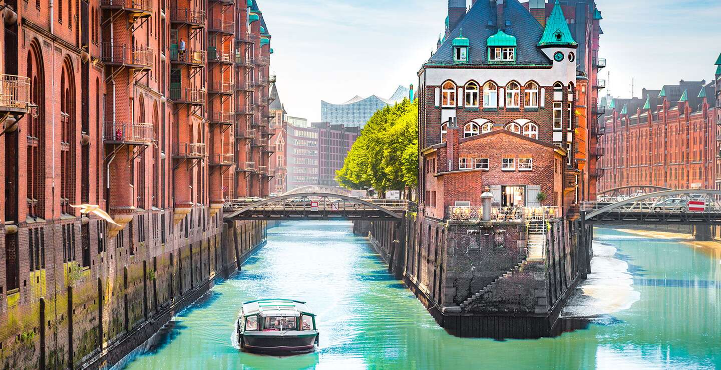 Speicherstadt in Hamburg mit einem Tourboot auf dem Wasser | © gettyimages.com