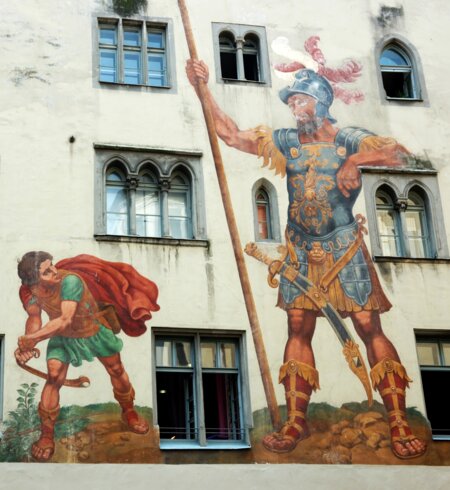 David und Goliath auf der Hausmauer in Regensburg, die zum unesco-Weltkulturerbe gehören | © Gettyimages.com/kaetana_istock