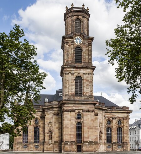 Ludwigskirche in Saarbrücken bei gutem Wetter mit grünen Bäumen | © Gettyimages.com/magann