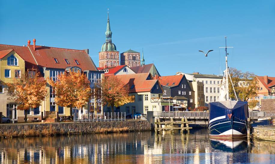 Angedockte Segelboote und Häuser im Kanal mit Backsteintürme Stralsund | © Gettyimages.com/anyaivanova