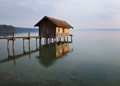 Traditionelle Bootshaus am Lake Dock bei Sonnenuntergang, Ammersee, Bayern | © Gettyimages.com/AVTG