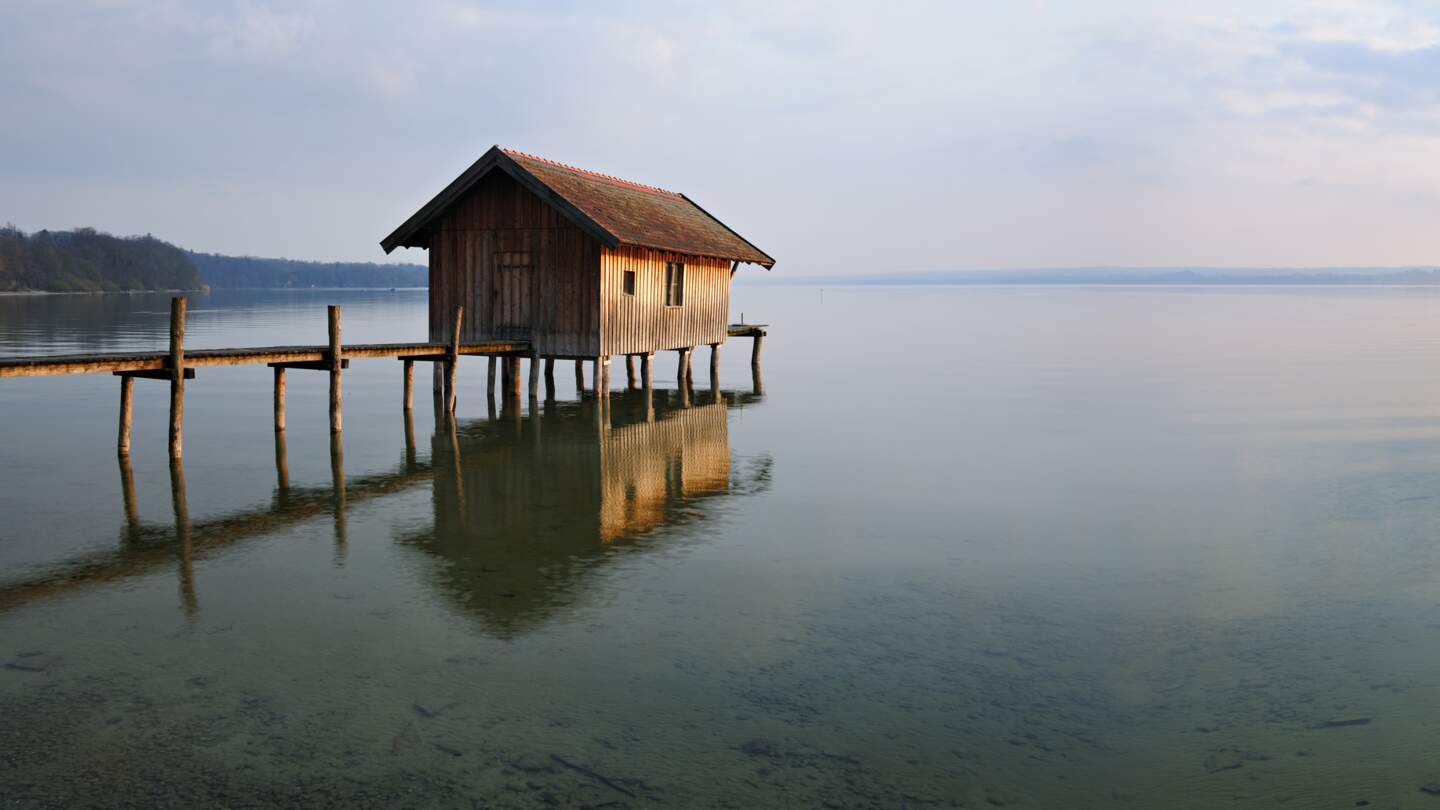 Traditionelle Bootshaus am Lake Dock bei Sonnenuntergang, Ammersee, Bayern | © Gettyimages.com/AVTG