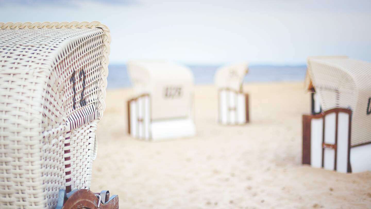  Strandkorbs aus Korbgeflecht, mit weiteren ähnlichen Stuehlen im Hintergrund  | © gettyimages.com/Rike_