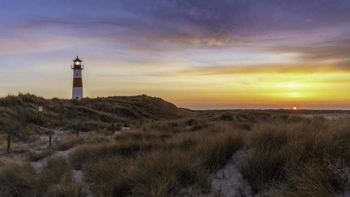 Panorama eines Teils der Insel Sylt namens "Ellenbogen" mit Leuchtturm List-Ost und Sonnenuntergang mit dramatischem Himmel | © Gettyimages.com/Jörg Hoffmann
