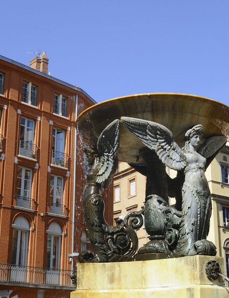 Blick auf französische Backsteingebäude und Brunnen in Toulouse, Place de la Trinite | © Gettyimages.com/yvon52 