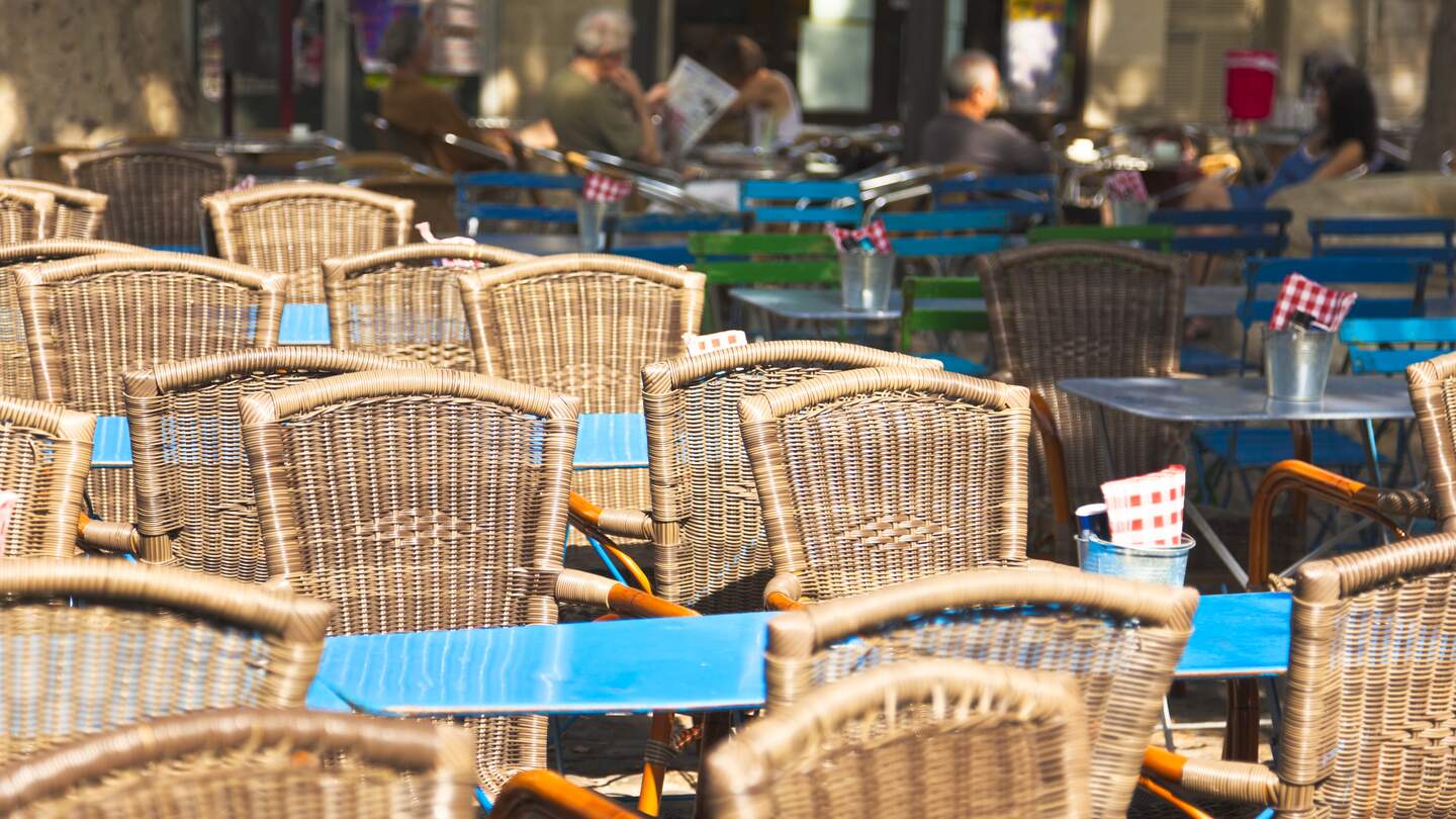 Straßenrestaurant mit vielen Stühlen unter der Sonne im Sommer in Avignon | © Gettyimages.com/Brzozowska