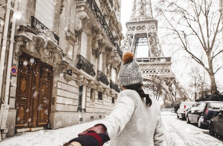Frau läuft zu Fuß zum Eiffelturm mit Schnee im Winter in Paris. | © Gettyimages.com/Orbon Alija