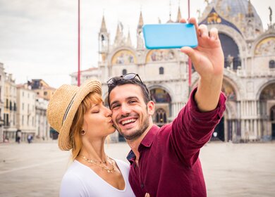 Schönes, junges Paar, das ein Selfie vor dem Markusdom in Venedig macht.  | © Gettyimages.com/Diamond Dogs