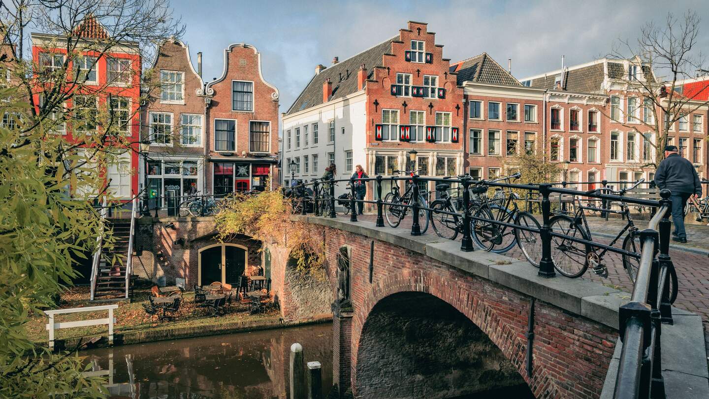  staedtische Szene mit einem Kanal, ueber den eine Steinbruecke mit Fahrraedern fuehrt | © Ruben Drenth