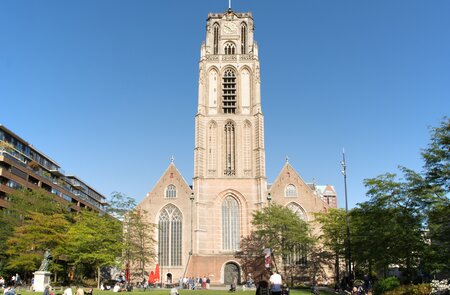 Blick auf die Laurenskerk (Laurens Kirche) mit Menschen, die die Sonne auf dem Grotekerkplein in Rotterdam, Niederlande  | © Gettyimages.com/kb79