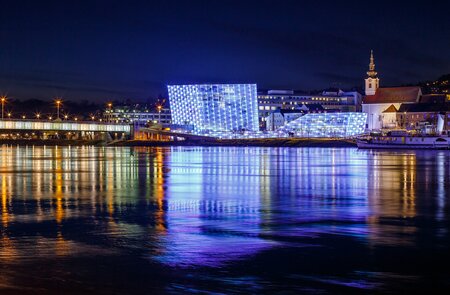 Beleuchtetes Ars Electronica Center Linz an der Donau in der Nacht | © Gettyimages.com/mmuenzl