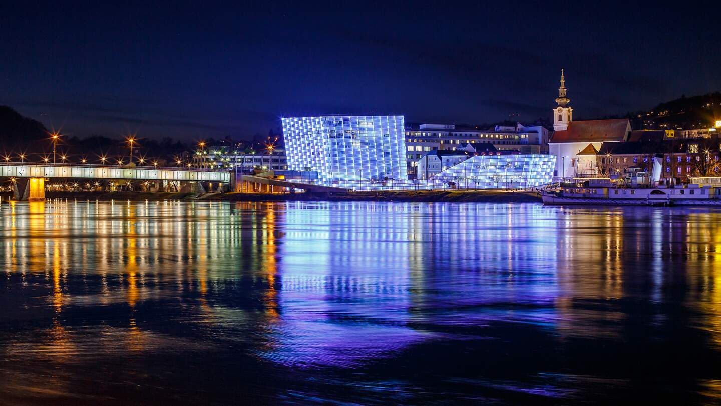Beleuchtetes Ars Electronica Center Linz an der Donau in der Nacht | © Gettyimages.com/mmuenzl