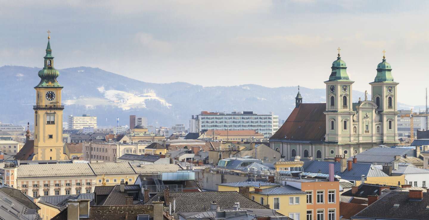 Blick über die Dächer der Altstadt von Linz mit Bergen im Hintergrund | © Gettyimages.com/Bertl123