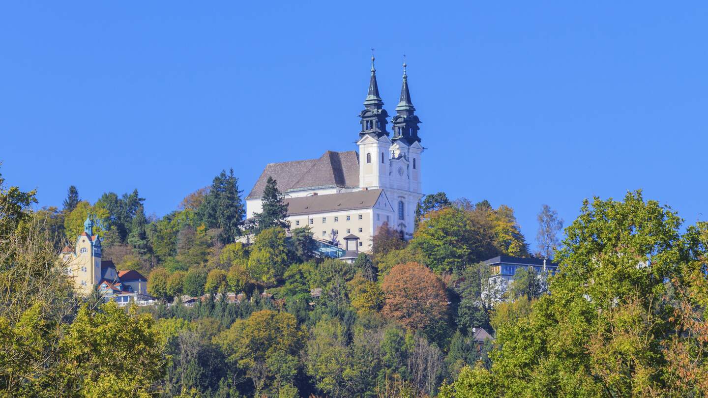 Blick auf die Basilika auf dem Poestlingberg  in Linz mit herbstlich gefärbten Bäumen | © Gettyimages.com/Bertl123