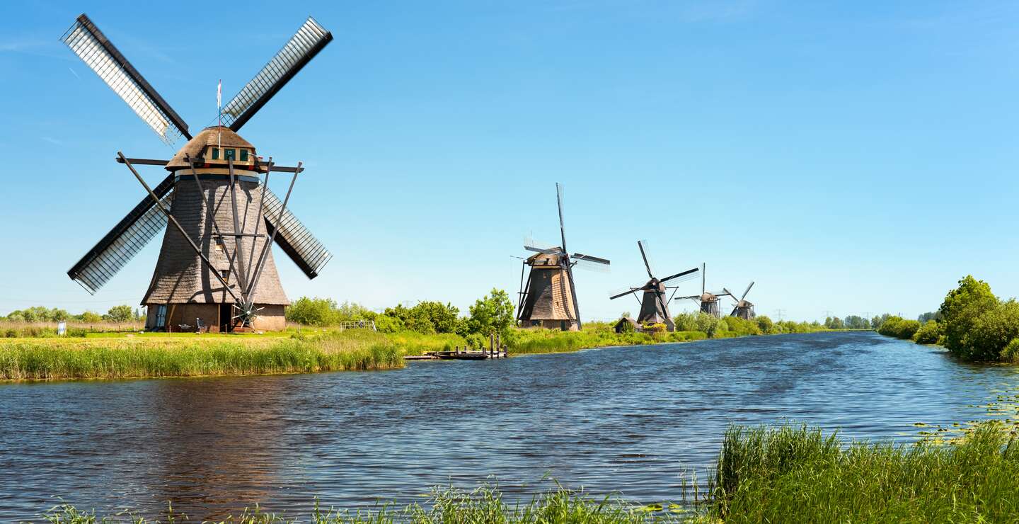 Mehrere Windmühlen nebeneinander anlamg eines Kanals | © Gettyimages.com/sergiyN