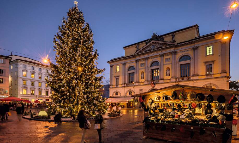 beleuchteter Weihnachtsbaum und Weihnachtsmarkt abends in Lugano | © Schweiz Tourismus/Jan Geerk