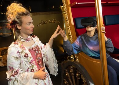 Kind in der Kutsche mit VR-Brillen und barocke Dame | © TimeRide GmbH