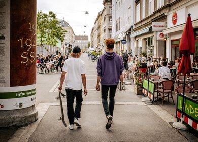 zwei Männer laufen mit Skateboards über den Yppenplatz	 | ©  WienTourismus/Paul Bauer
