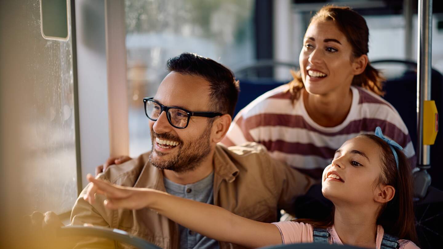 Glückliche Familie, die es genießt, in einem Bus zu fahren | © Gettyimages.com/Drazen Zigic