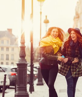 Freundinnen laufen im Herbst ueber die Strasse in Paris | © Gettyimages.com/martin-dm