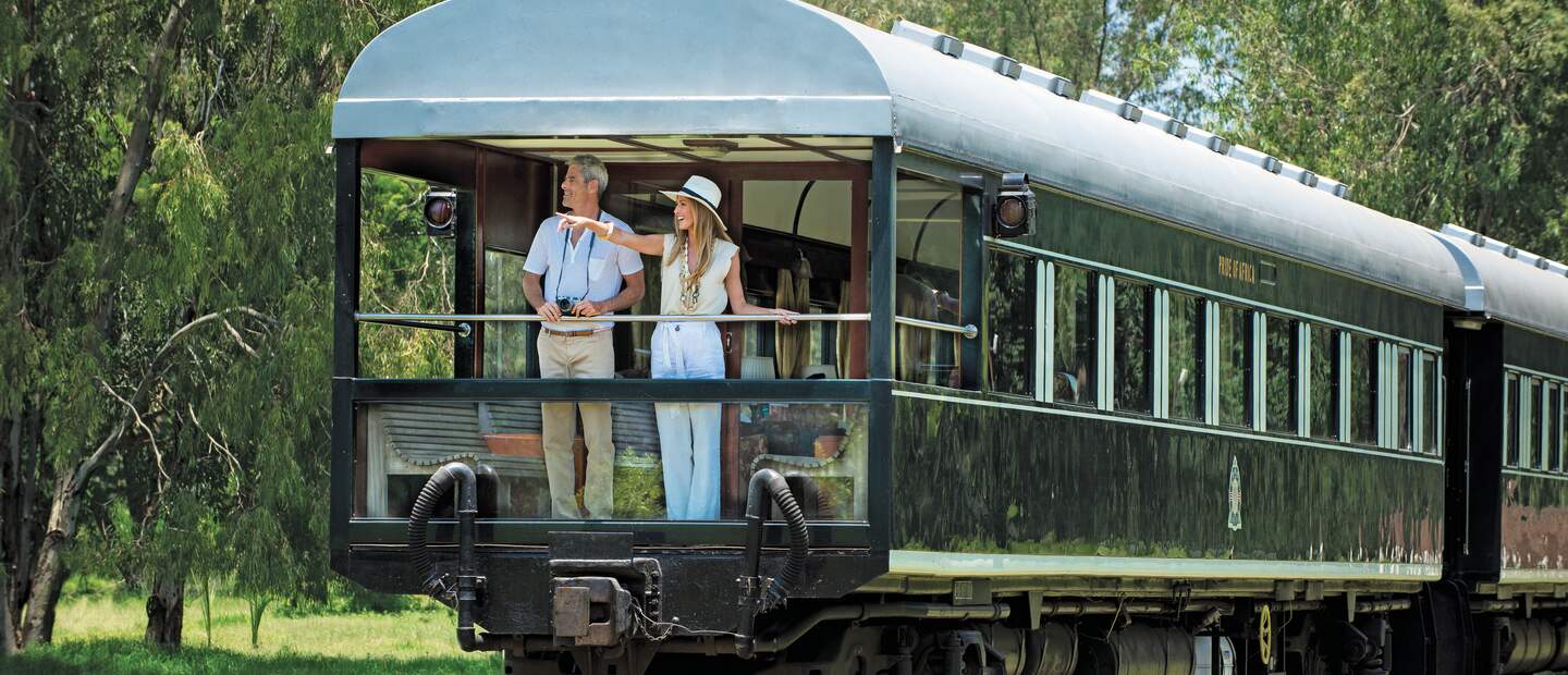 Ein schoenes Paar geniesst die Natur vom Balkon des Rovos Rail  | © DOOKPHOTO