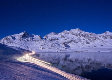 Im Panoramawagen des Bernina Expresses mit hoher Geschwindigkeit nachts im Winter in der Schweiz | © Rhätische Bahn/Christoph Benz