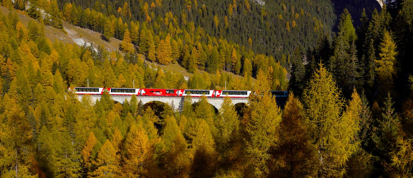 Der Glacier Express fährt durch das Albulatal in der Schweiz im Herbst | © Glacier Express AG/Stefan Schlimpf