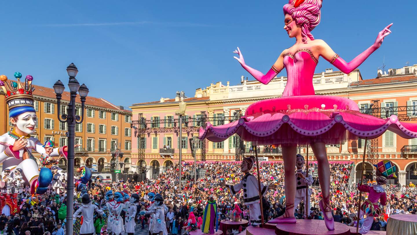 Carnaval de Nice mit dem Thema König des Kinos - Tanzende Ballerina-Wagen blickt mit Hunderten von Menschen im Publikum auf den König des Karnevals zurück | © Gettyimages.com/Michelle Silke
