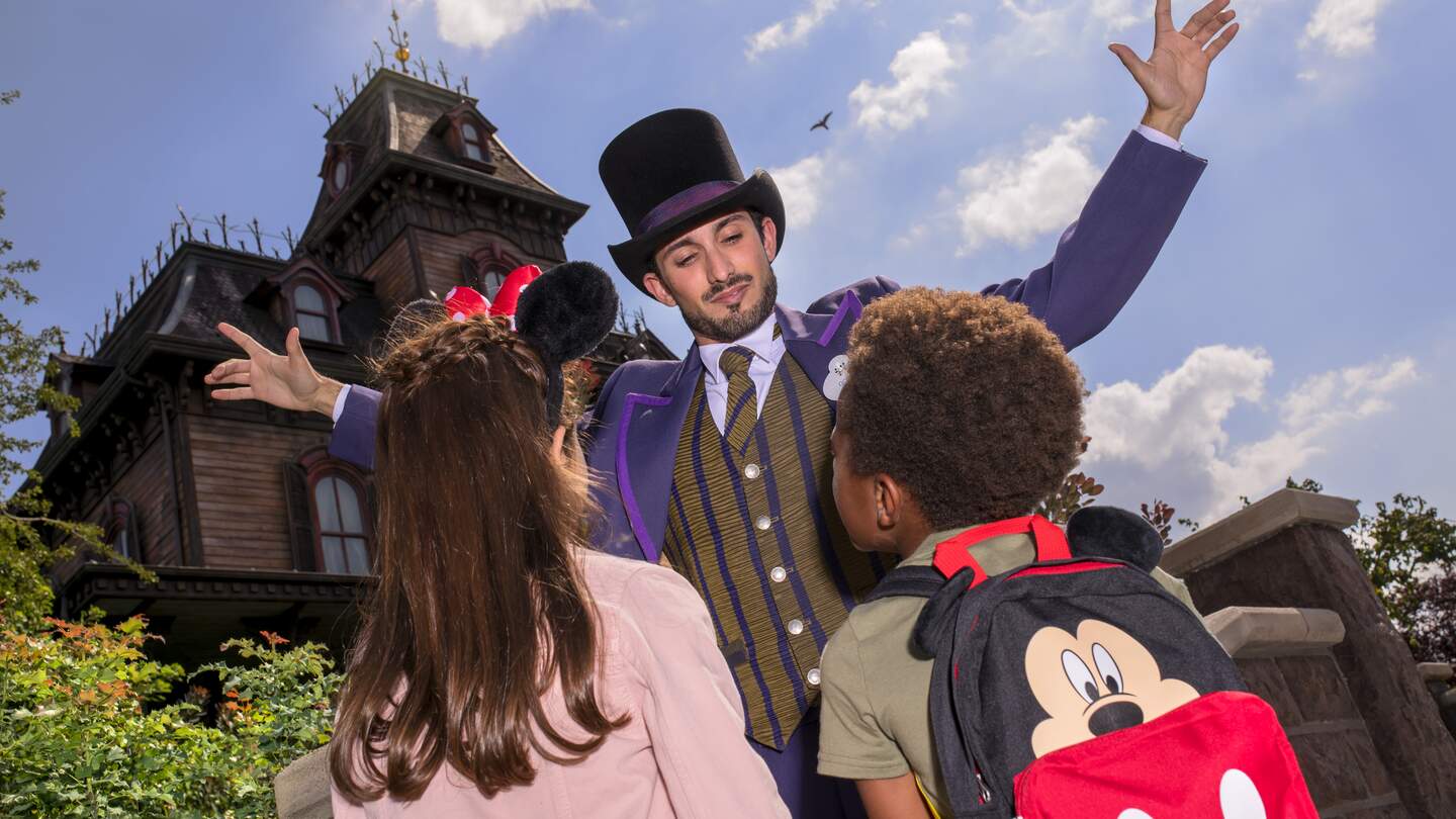 Cast Member und Kinder vor der Attraktion Phantom Manor in Disneyland® Park | © Disney