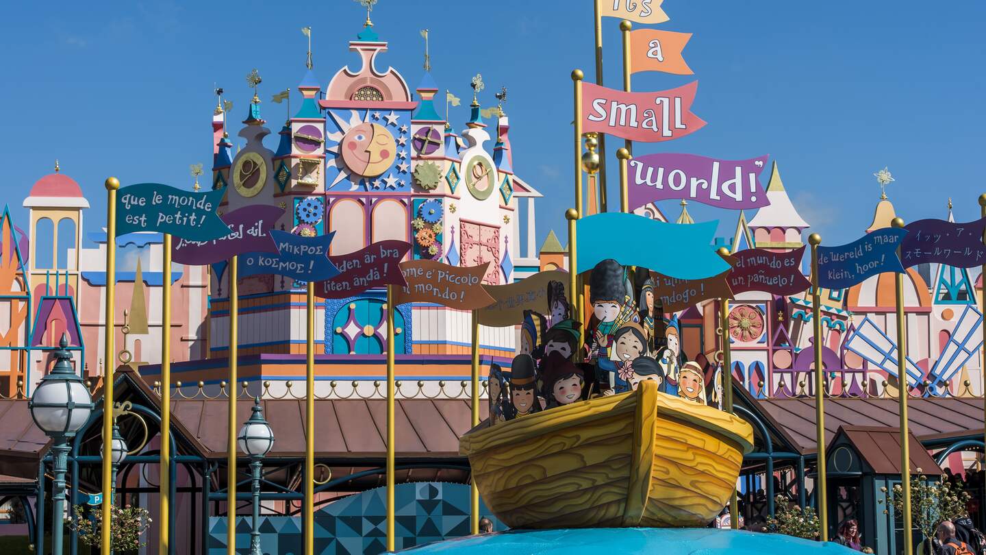 Eingang zur Attraktion Small World in Disneyland® Park mit Fahnen und Boot | © Disney
