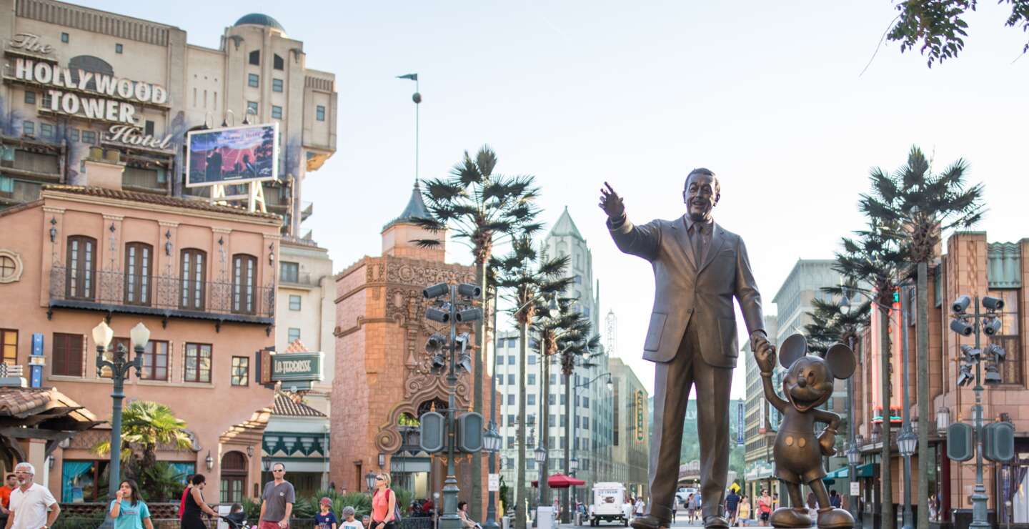 Walt Disney Studios® Park Partners Statue Walt Disney und Micky Maus halten Hand, im Hintergrund die Attraktion The Twilight Zone Tower of Terror | © Disney / CBS, Inc.