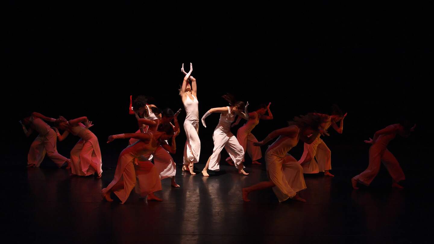 Gruppe von modernen Tänzer auf der dunklen Bühne bei ihrer Tanzaufführung | © Gettyimages.com/elkor