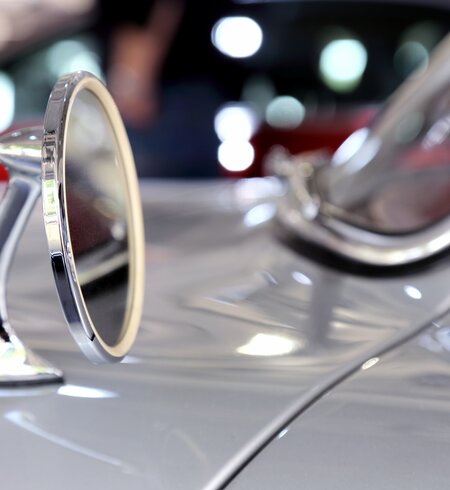 Nahaufnahme eines Spiegels eines silberfarbenen Mercedes-Benz 300  | © © Gettyimages.com/vuk8691